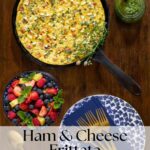 Overhead view of a ham and cheese frittata in a cast iron skillet with goat cheese and fresh herbs, served with a bowl of mixed berries, gold flatware, and a blue floral plate; text overlay reads “Ham & Cheese Frittata with Goat Cheese & Fresh Herbs – thecafesucrefarine.com.”