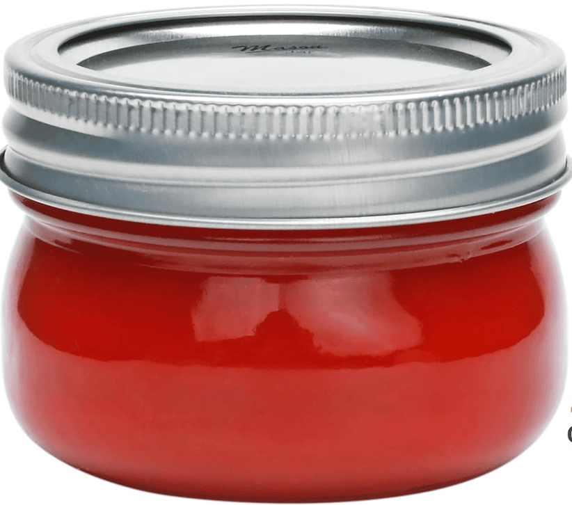 Mini mason jar with red contents and a silver lid.