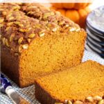 Pumpkin bread sliced on a blue and white kitchen towel.