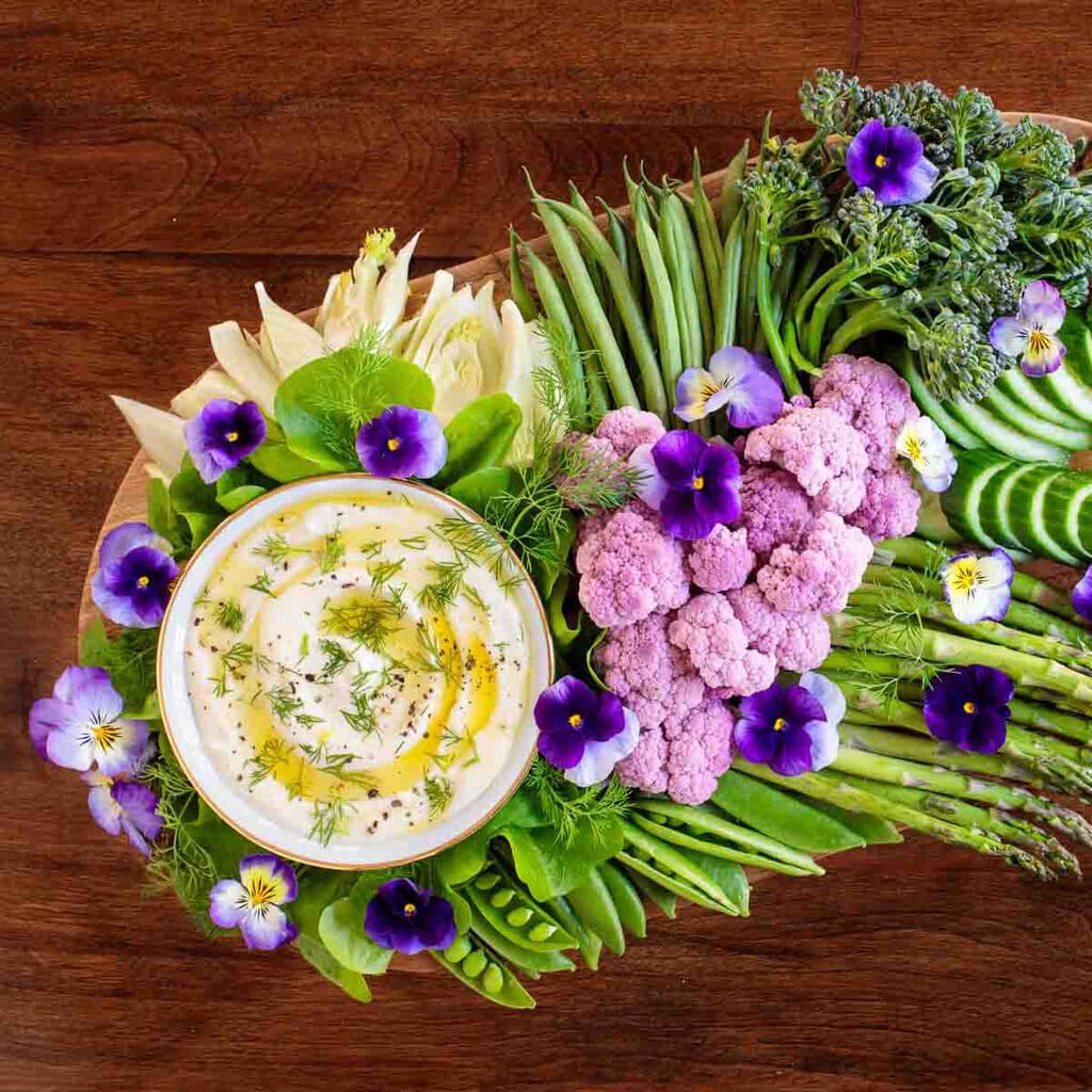 Party dip beautifully displayed with fresh flowers around it.