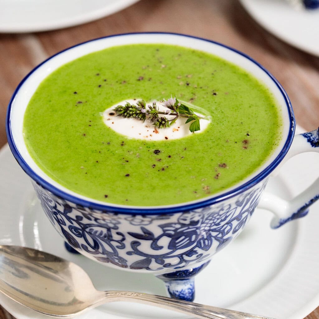 Creamy green soup in a decorative blue and white soup bowl.