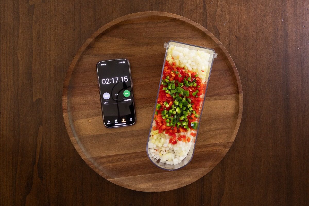 Overhead photo showing chopped vegetables in a Vidalia chopper next to an iPhone timer reading 2:17, demonstrating how fast the prep was for Pumpkin Chili.