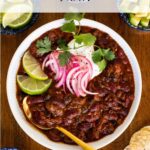 Short rib chili in a white bowl with toppings.