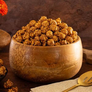 Wooden bowl filled with golden snickerdoodle caramel corn.