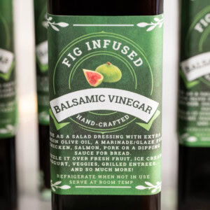 Close-up of a bottle of homemade Fig-Infused Balsamic Vinegar with green printable label reading 