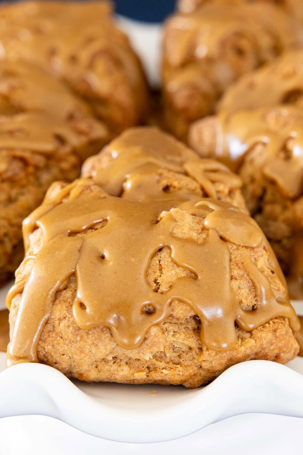 Close-up of carrot cake scone topped with thick brown sugar caramel glaze