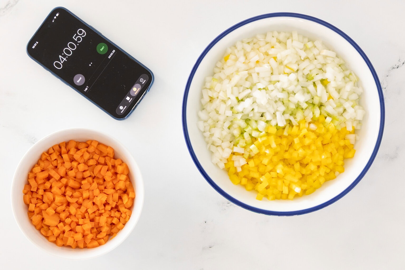 Bowls of finely diced onion, celery, yellow bell pepper, and carrots for Italian Grandmother Minestrone, with a timer showing quick vegetable prep time.