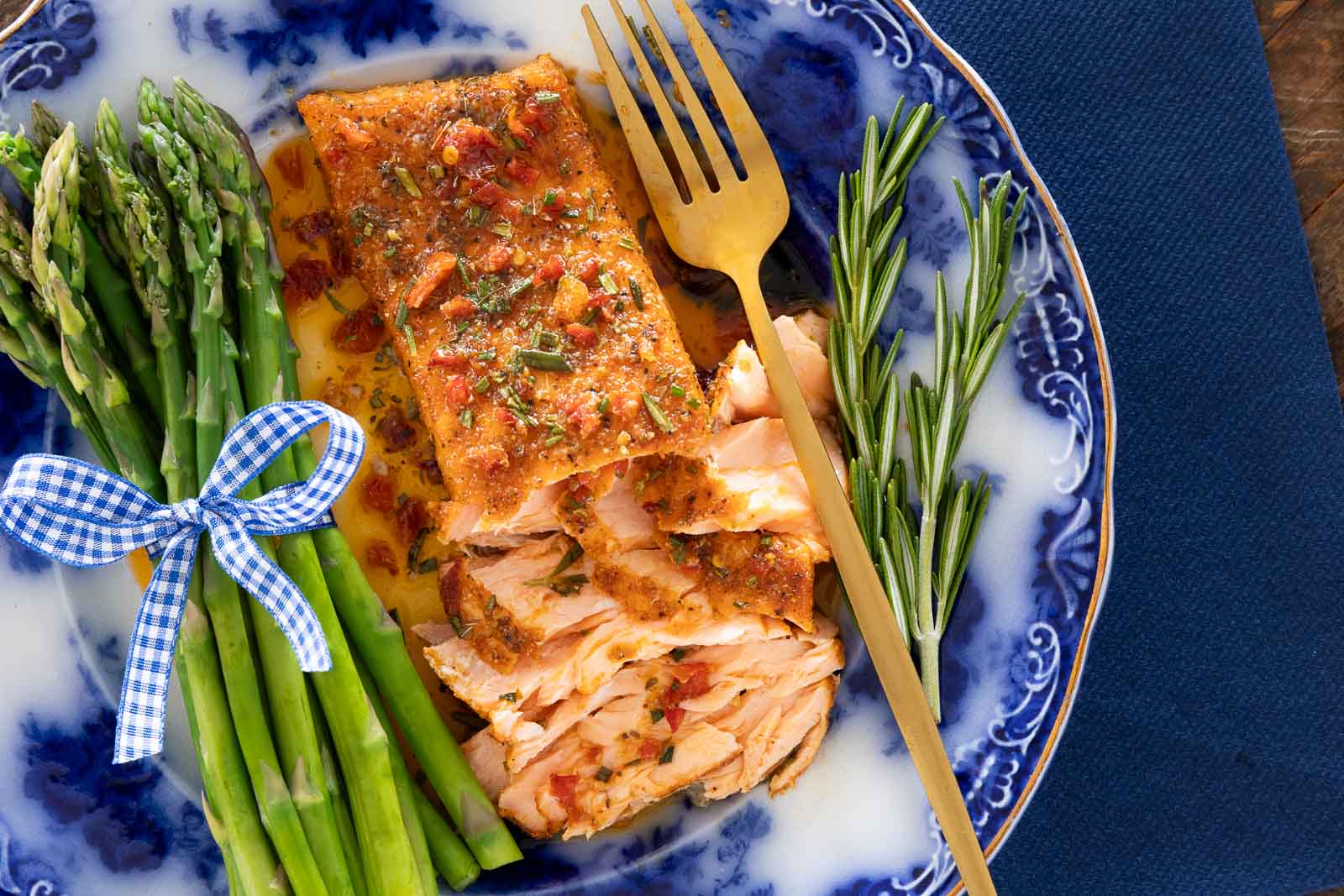 Pan-seared salmon topped with garlic herb butter and sun-dried tomatoes served with asparagus on a blue plate.
Pan-seared salmon is often paired with vegetables like asparagus because both cook quickly and complement each other’s flavor and texture, making them a popular combination for simple weeknight meals.