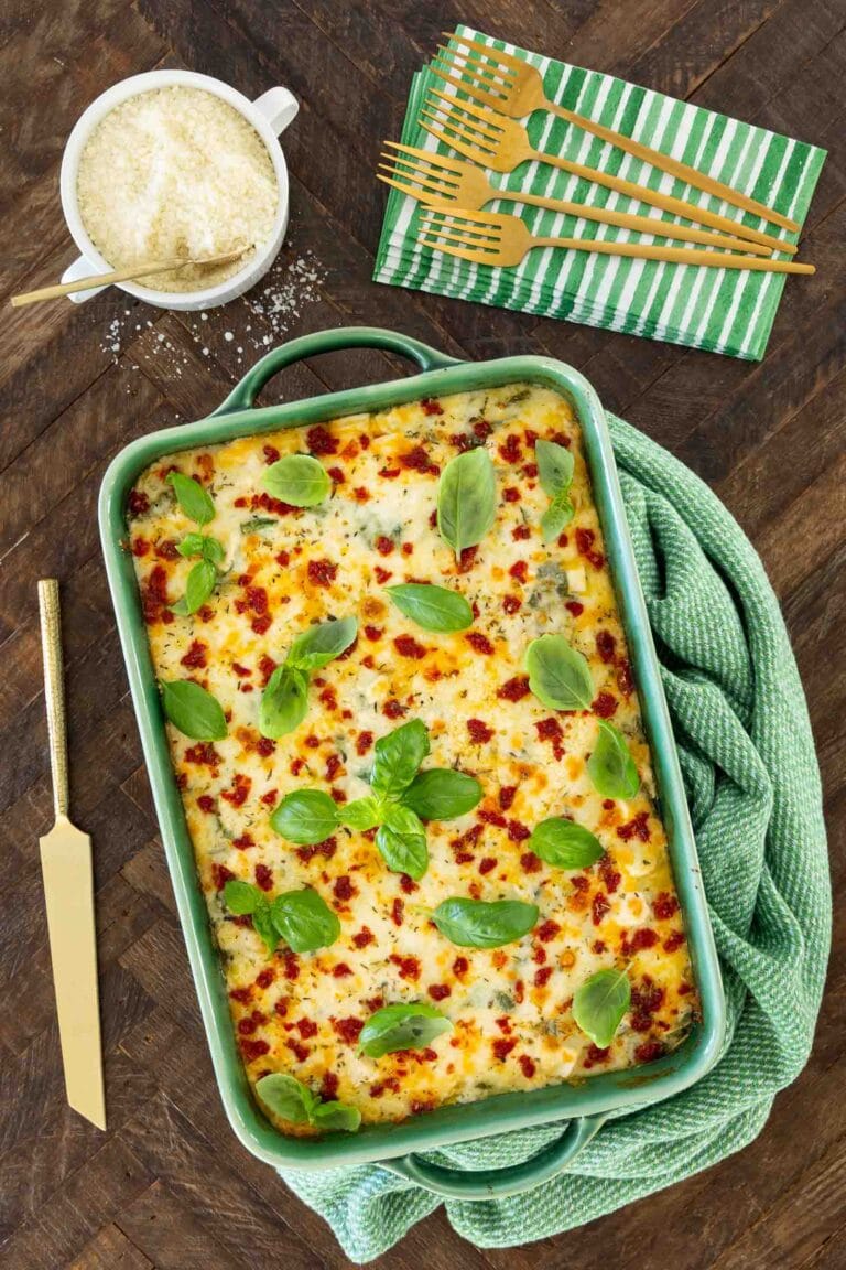 Italian Chicken and Spinach Ravioli Lasagna in a green baking dish on a green kitchen towel.