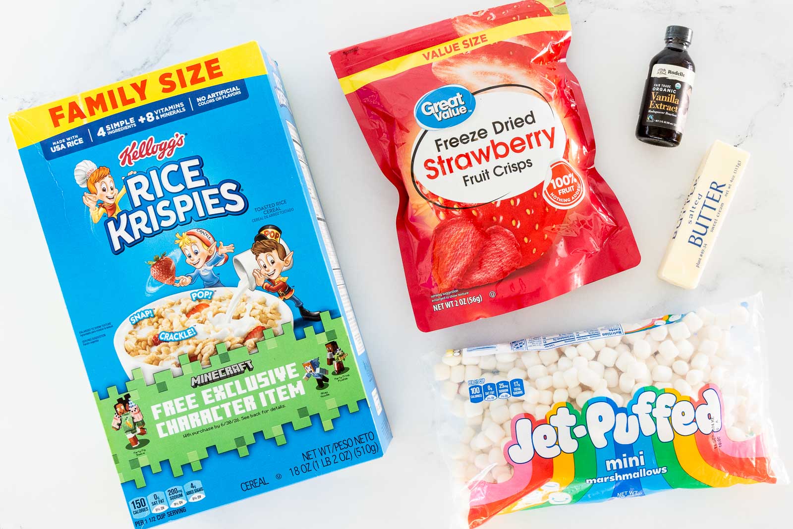 Ingredients for strawberry rice krispie treats including Rice Krispies cereal, mini marshmallows, butter, vanilla and freeze-dried strawberries