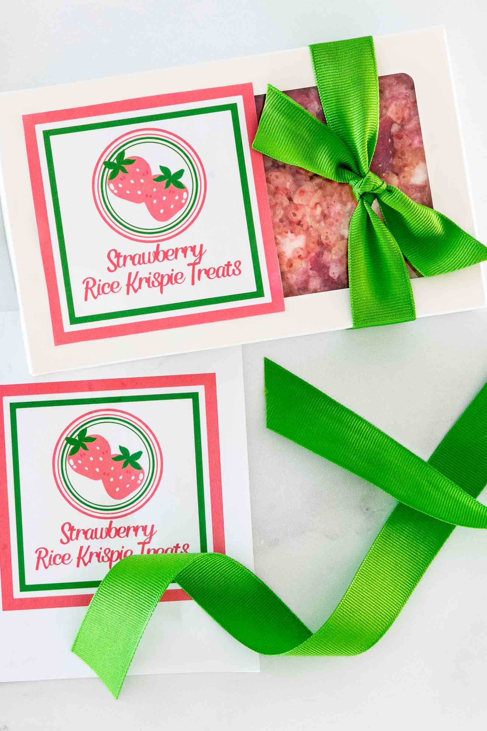 Strawberry Rice Krispie treats packaged in a gift box with green ribbon and printable strawberry label