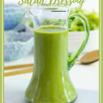 Pinterest graphic for Honey Lemon Mint Salad Dressing featuring a glass cruet filled with bright green homemade dressing on a table with soft blue dishes in the background.