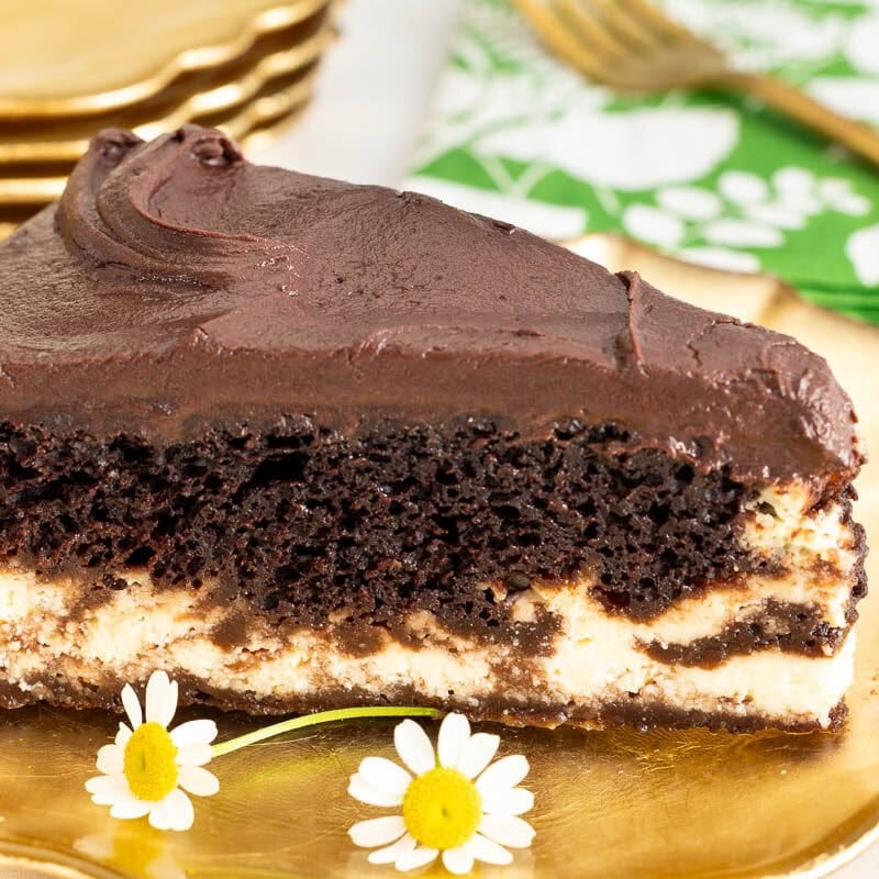 Slice of Marry Me Italian Love Cake with chocolate cake, creamy ricotta layer and chocolate frosting on a gold dessert plate.