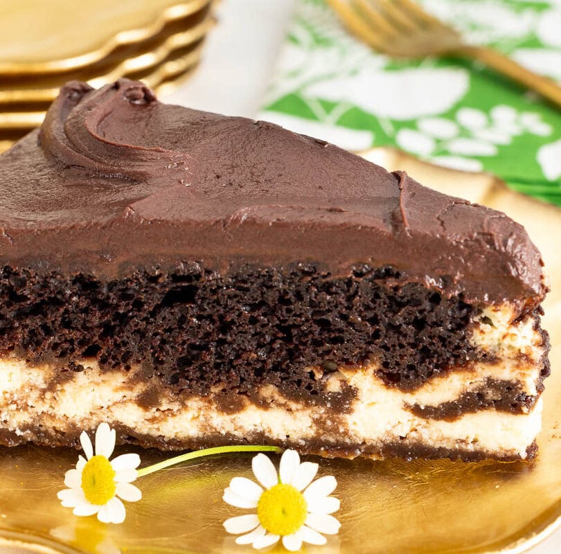 Slice of Marry Me Italian Love Cake with chocolate cake, creamy ricotta layer and chocolate frosting on a gold dessert plate.