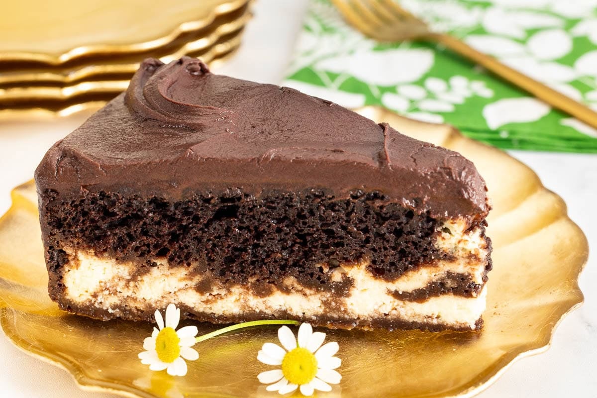 Slice of Marry Me Italian Love Cake with chocolate cake, creamy ricotta layer and chocolate frosting on a gold dessert plate.