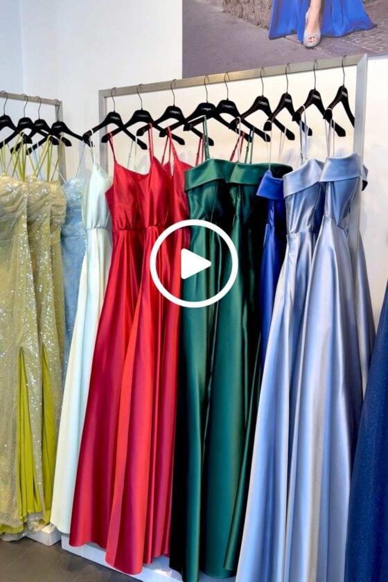 Colorful satin and sequined evening gowns displayed in the window of a fashion boutique in Milan, Italy.