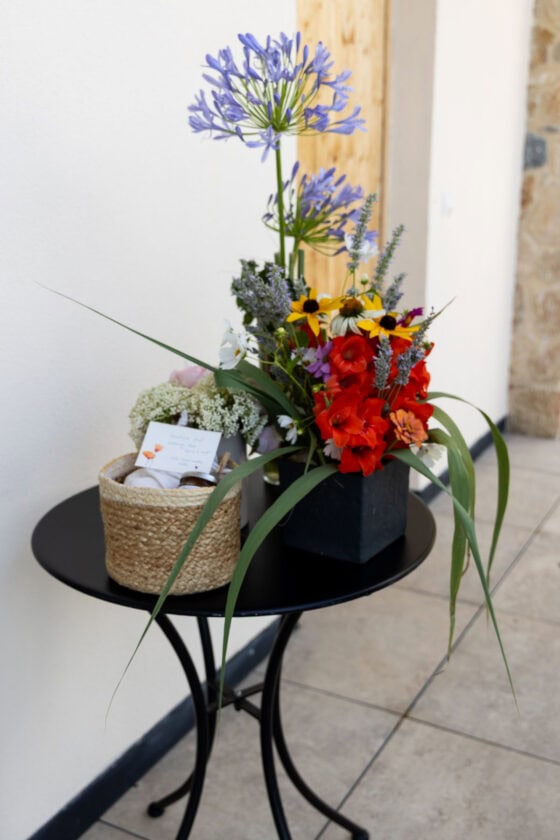 Fresh flowers and a welcome basket with a handwritten note greeting guests at a Lake Garda Airbnb.