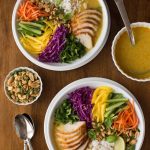 Overhead picture of two bowls of vietnamese chicken soup with lots of toppings