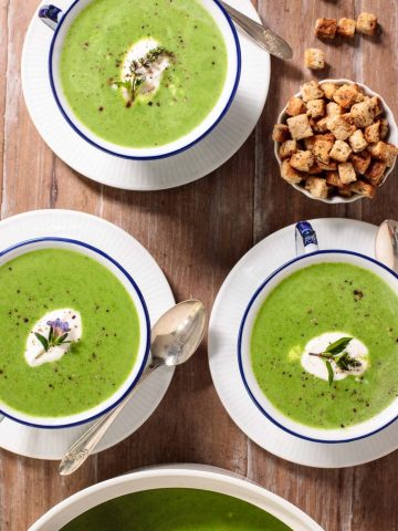 Overhead picture of Fresh Spinach Soup in small blue and white bowls with croutons
