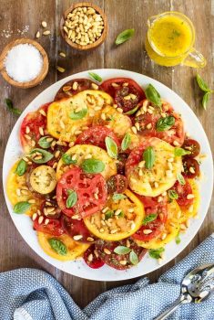 Overhead picture of summer tomato salad on a wooden table