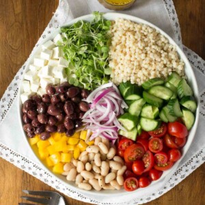 Overhead picture of Best Ever Greek Salad with ingredients grouped together in a white bowl