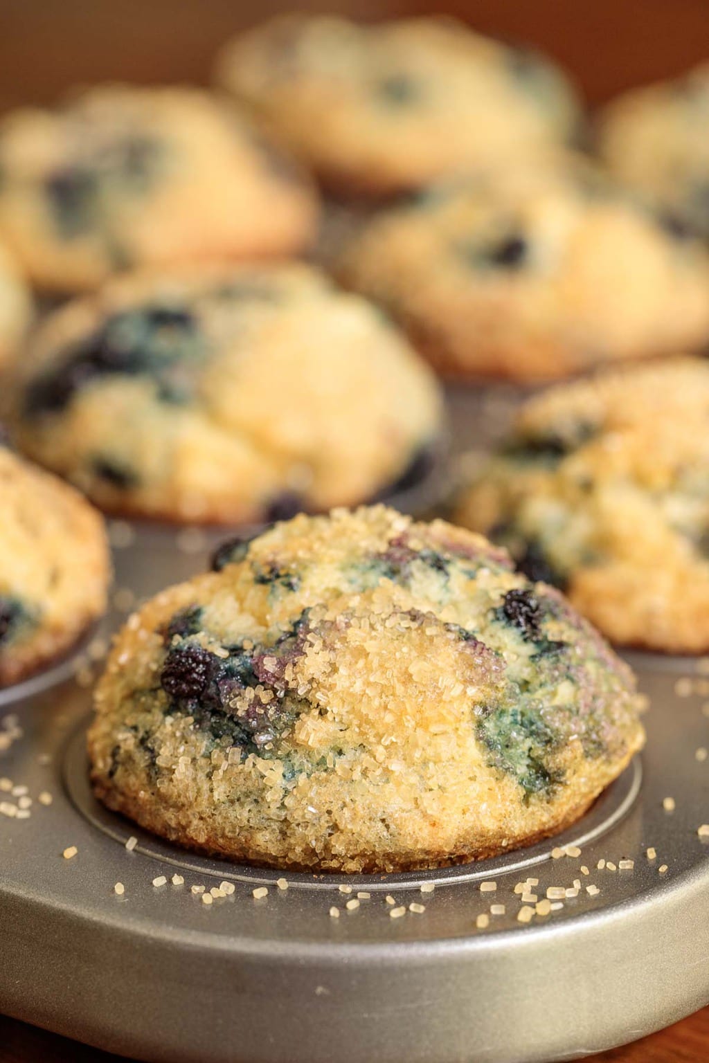 Extreme closeup vertical photo of a muffin baking pan filled with Copycat Starbuck's Blueberry Muffins.