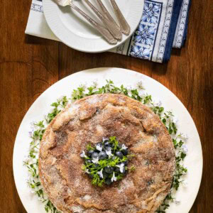 Overhead picture of Blueberry Buttermilk Breakfast Cake on a white plate with forks and napkins