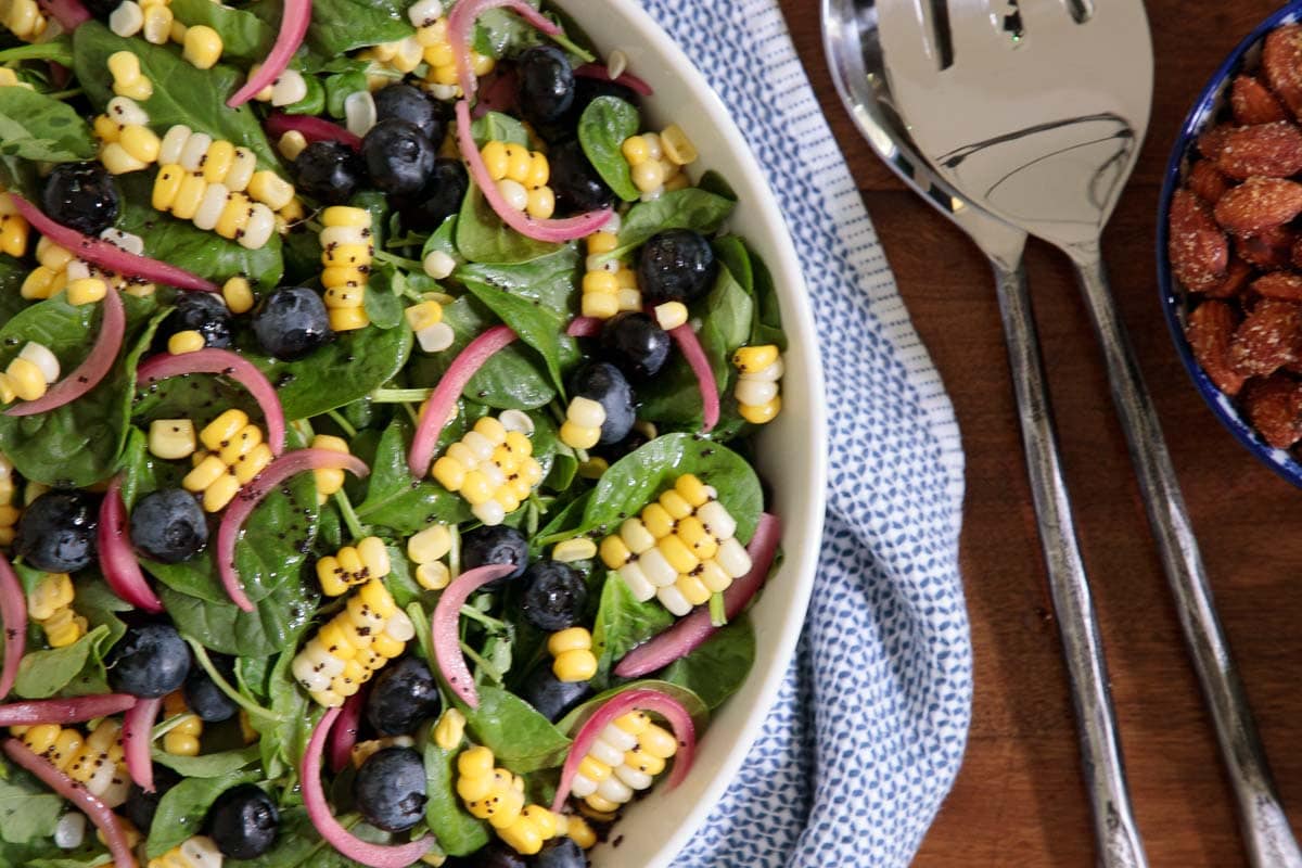 Overhead closeup of part of a bowl of Fresh Corn Blueberry Spinach Salad.