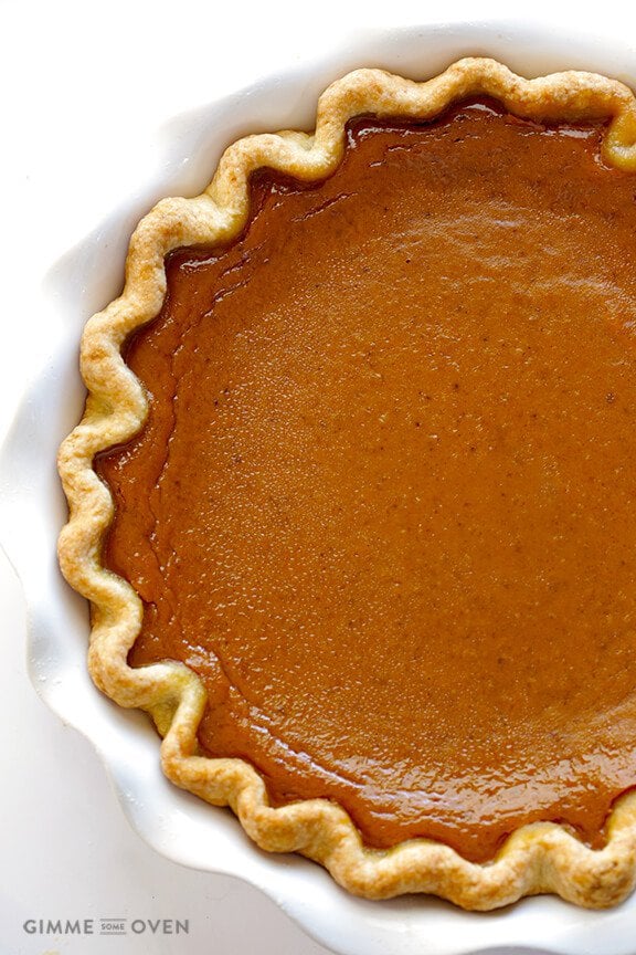 Overhead photo of a Bourbon Pumpkin Pie in a white dish on a white background. From "19 Delicious Thanksgiving Sides" blog post.