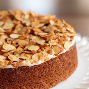 Vertical close up picture of a buttermilk crunch cake on a white cake stand