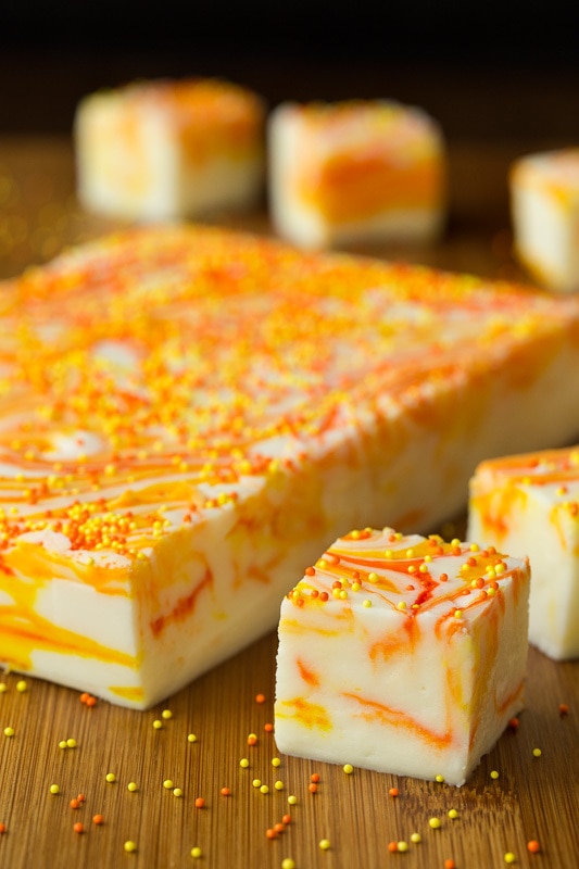 Vertical picture of Candy Corn Swirled Fudge cut into squares on a wooden table