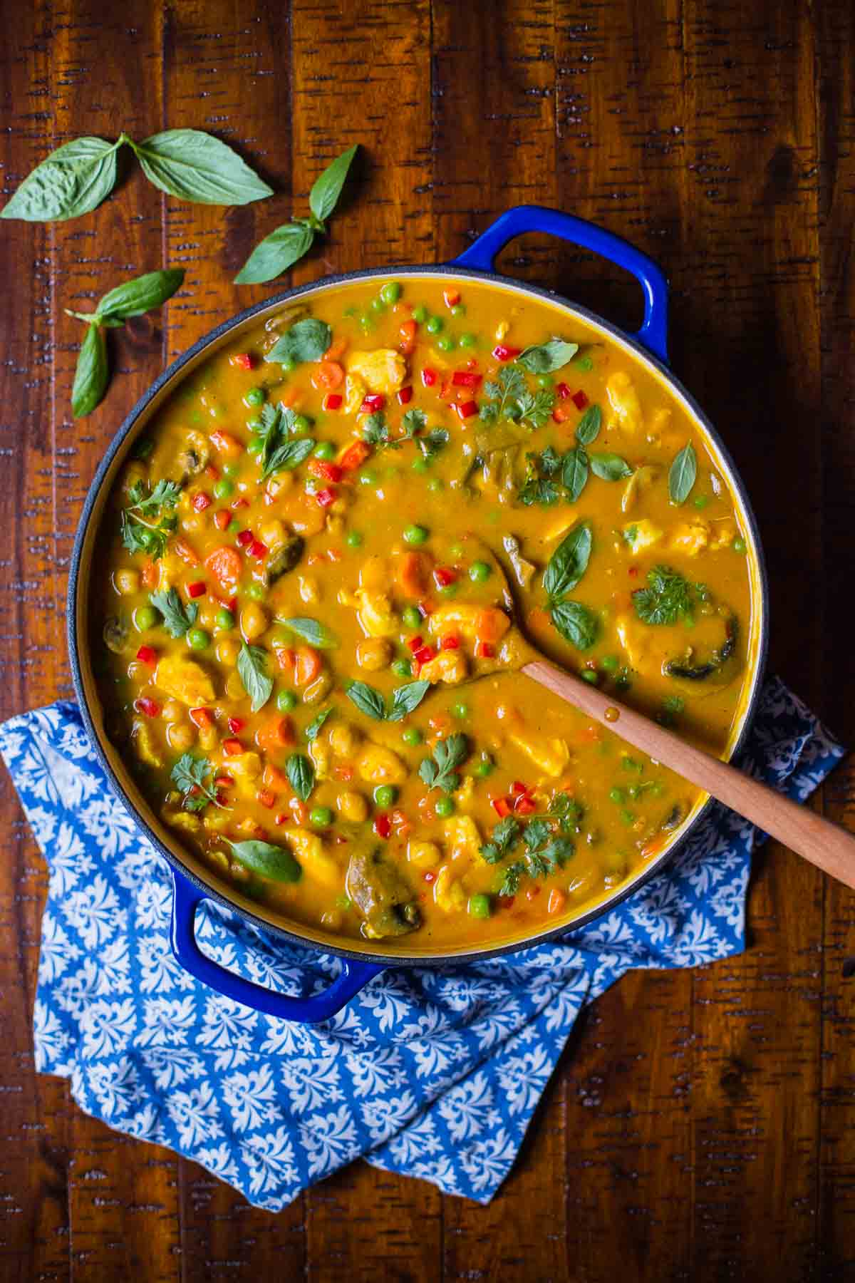 Overhead picture of Chicken, Carrot and Chickpea Coconut Curry in a blue skillet on a wooden table