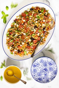 Vertical overhead picture of Chopped Mediterranean Farro Salad on a white oval platter