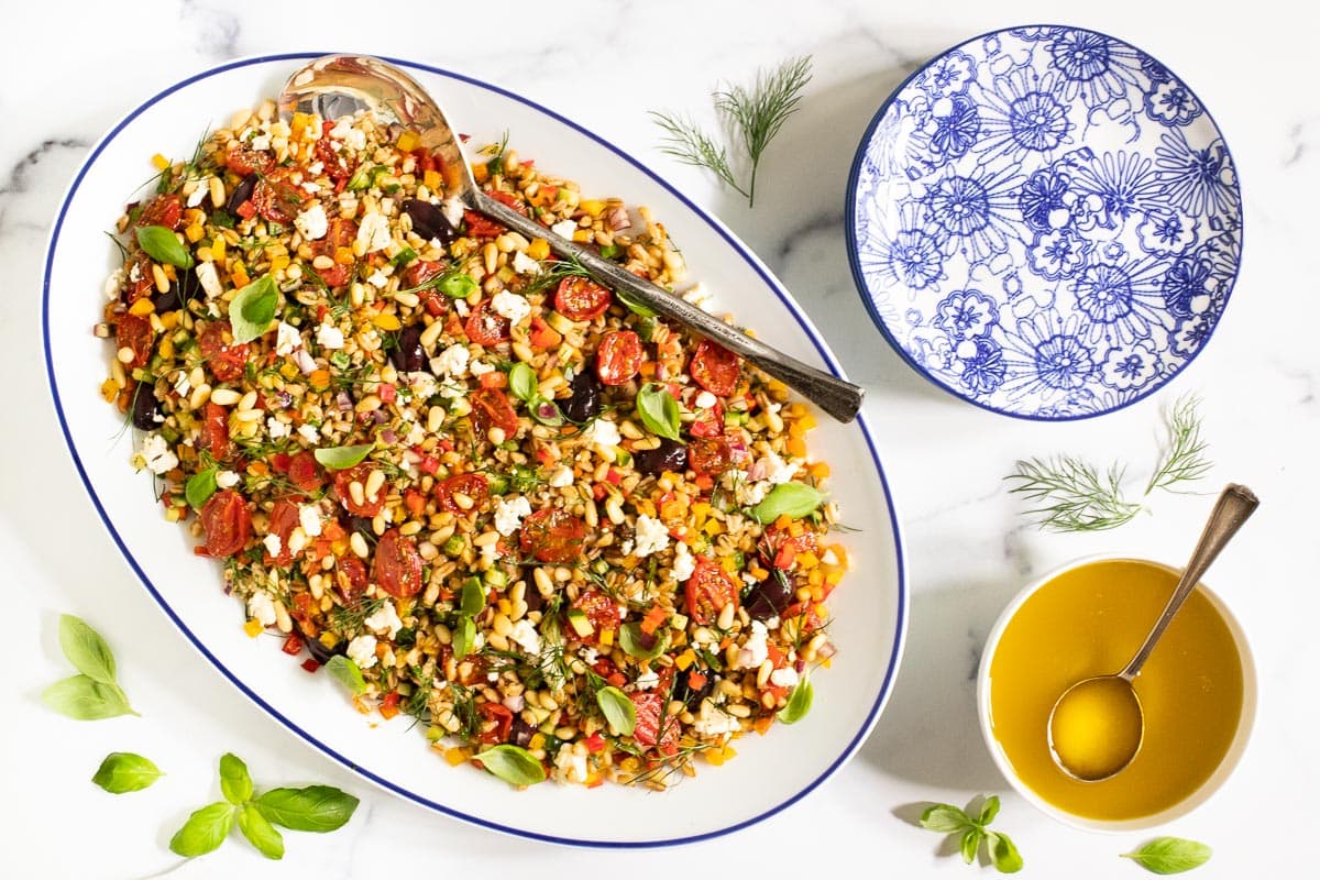 Overhead horizontal photo of a Chopped Mediterranean Farro Salad in a white and blue oval serving dish.