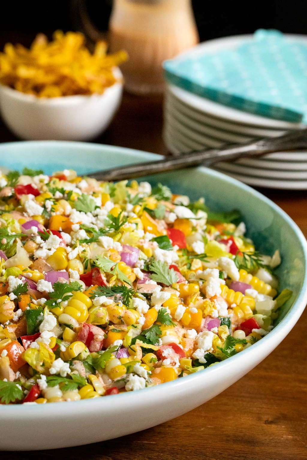 Vertical photo of Chopped Mexican Street Corn Salad in a white and turquoise serving bowl.