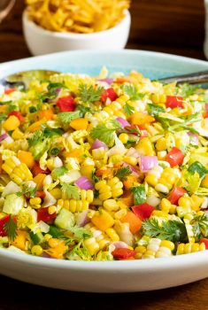 Horizontal closeup photo of Chopped Mexican Street Corn Salad in a white and turquoise serving bowl.