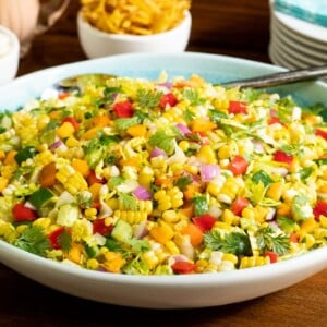 Horizontal closeup photo of Chopped Mexican Street Corn Salad in a white and turquoise serving bowl.