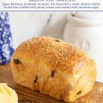 Closeup vertical photo of a loaf of Cinnamon Raisin Brioche Bread on a wood bread cutting board.
