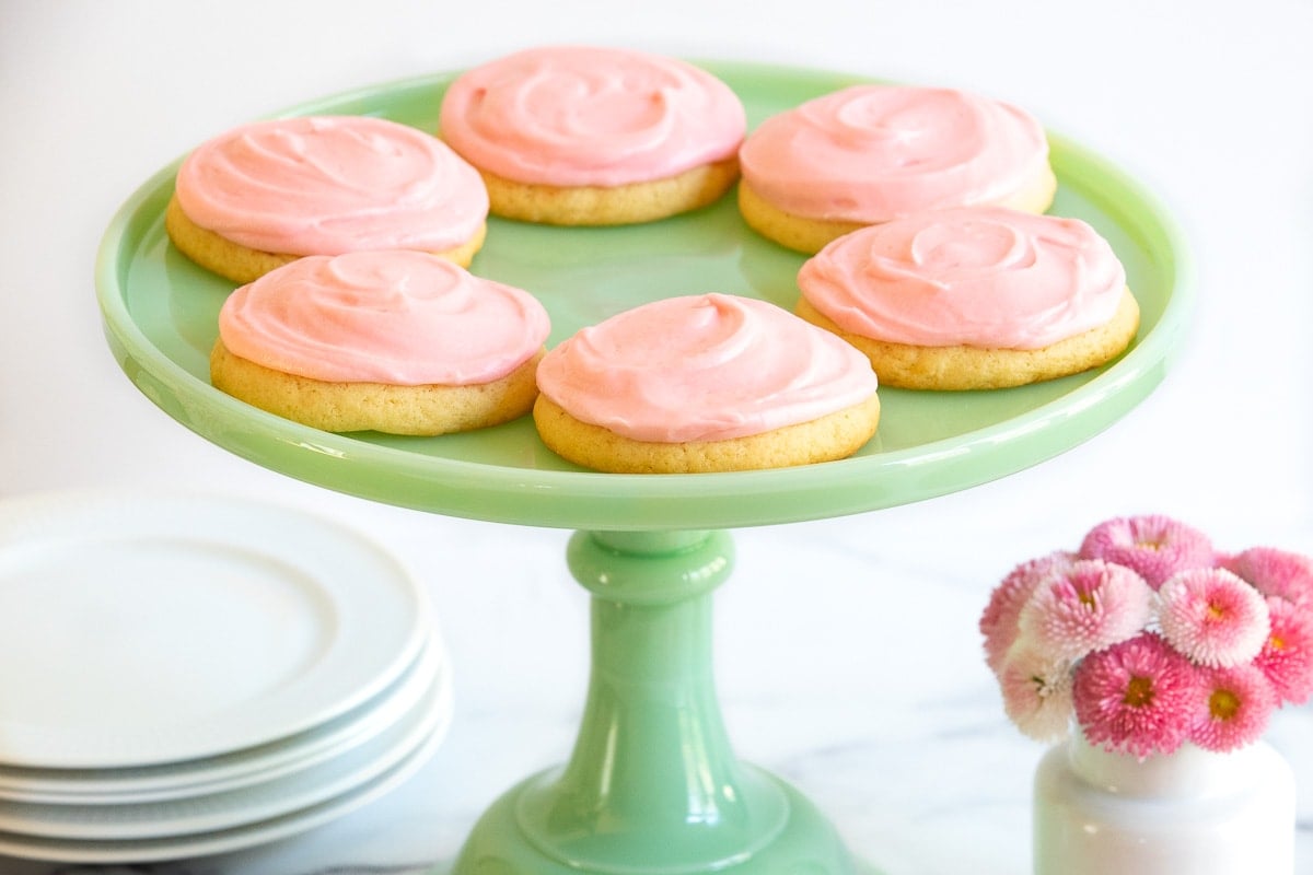 Horizontal photo of a jade green marble pedestal plate filled with Copycat Crumbl Sugar Cookies.