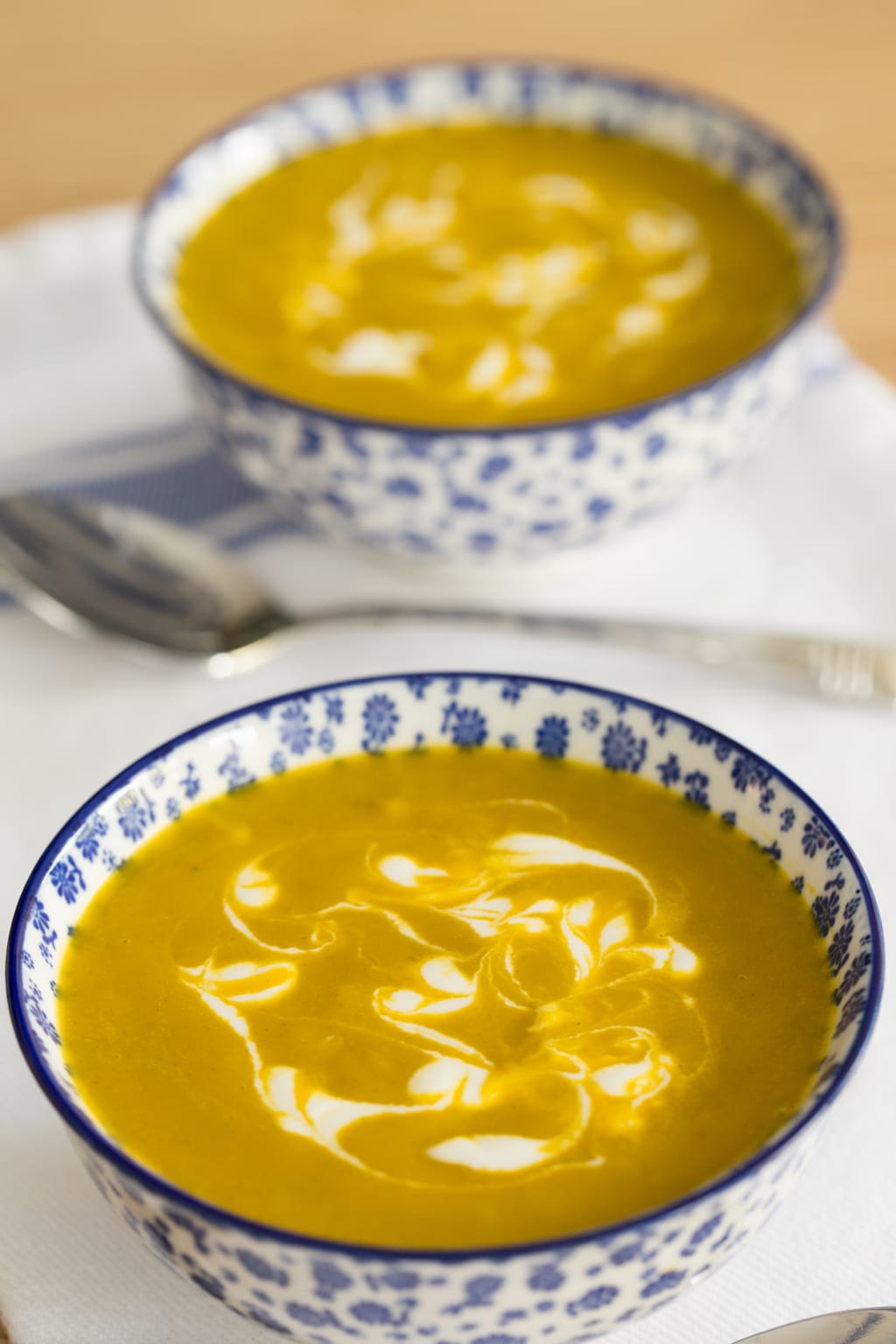 Photo of two blue and white patterned bowls of Carrot Coriander Soup.