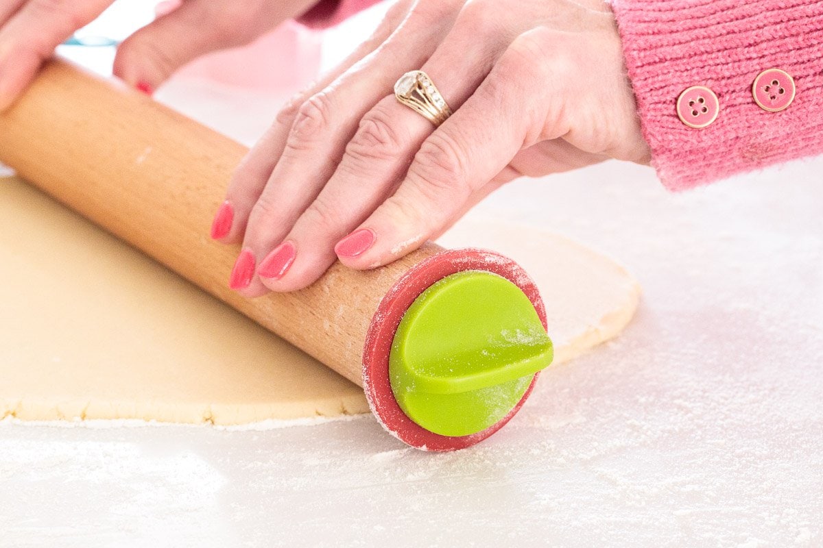 Horizontal photo of a person rolling out dough for making Mexican Sugar Cinnamon Shortbread.