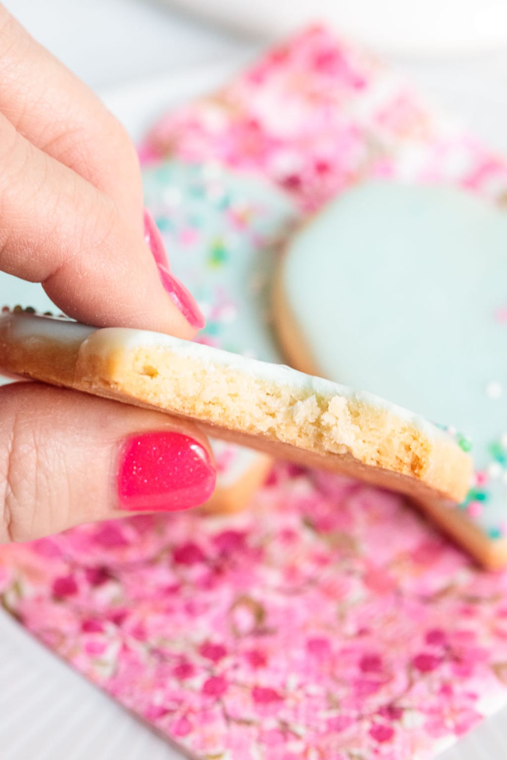 A vertical extreme closeup photo of the crumb texture of a Dip, Drip and Flip Shortbread Valentine Cookie.