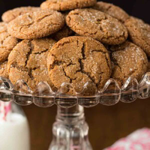 Vertical picture of ginger molasses cookies piled on a cake stand