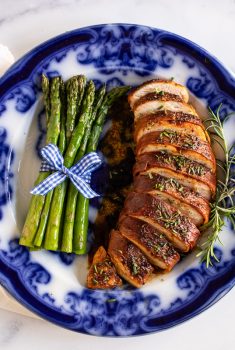Horizontal overhead photo of Prosciutto-Wrapped Chicken Breasts on a flow blue serving plate.