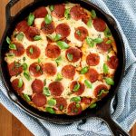 Overhead picture of deep dish pepperoni pizza in a cast iron skillet