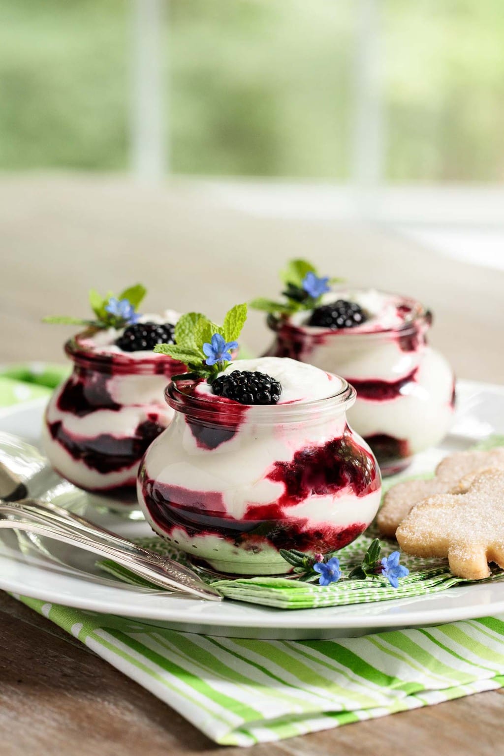 Photo of a white serving plate filled with Irish Blackberry Fool desserts in individual glass serving containers.