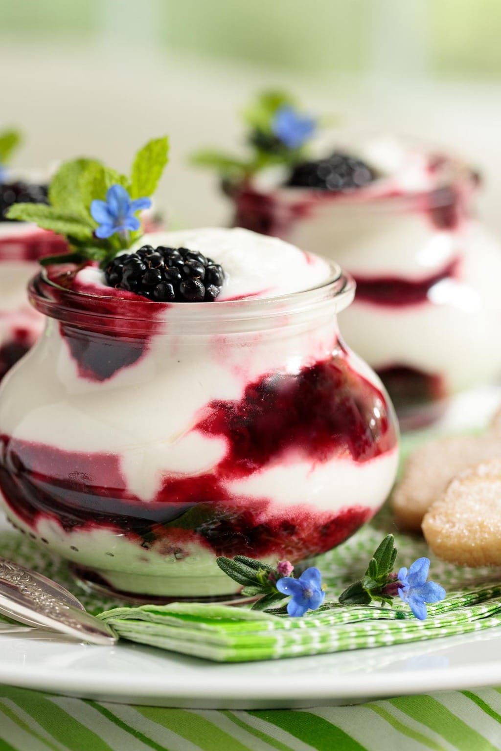 Photo of a white dessert platter filled with Irish Blackberry Fool desserts in glass Weck jars.