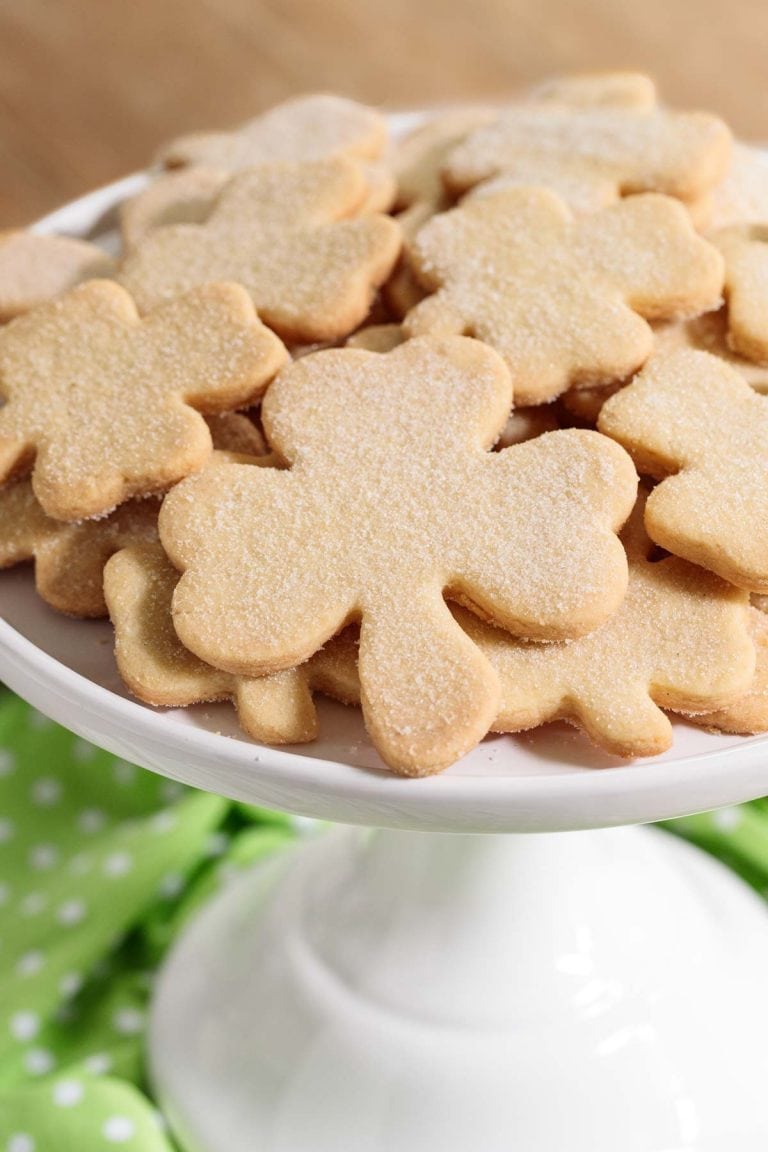 Vertical picture of shamrock shortbread cookies on a white cake stand