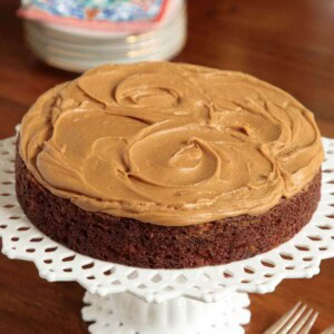 Vertical picture of easy magic apple cake on a white cake stand