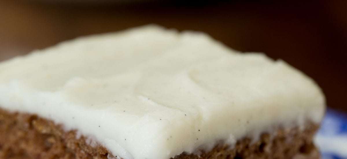 Photo of a piece of Easy Gingerbread Cake with Vanilla Bean Icing on a delft blue patterned serving plate.